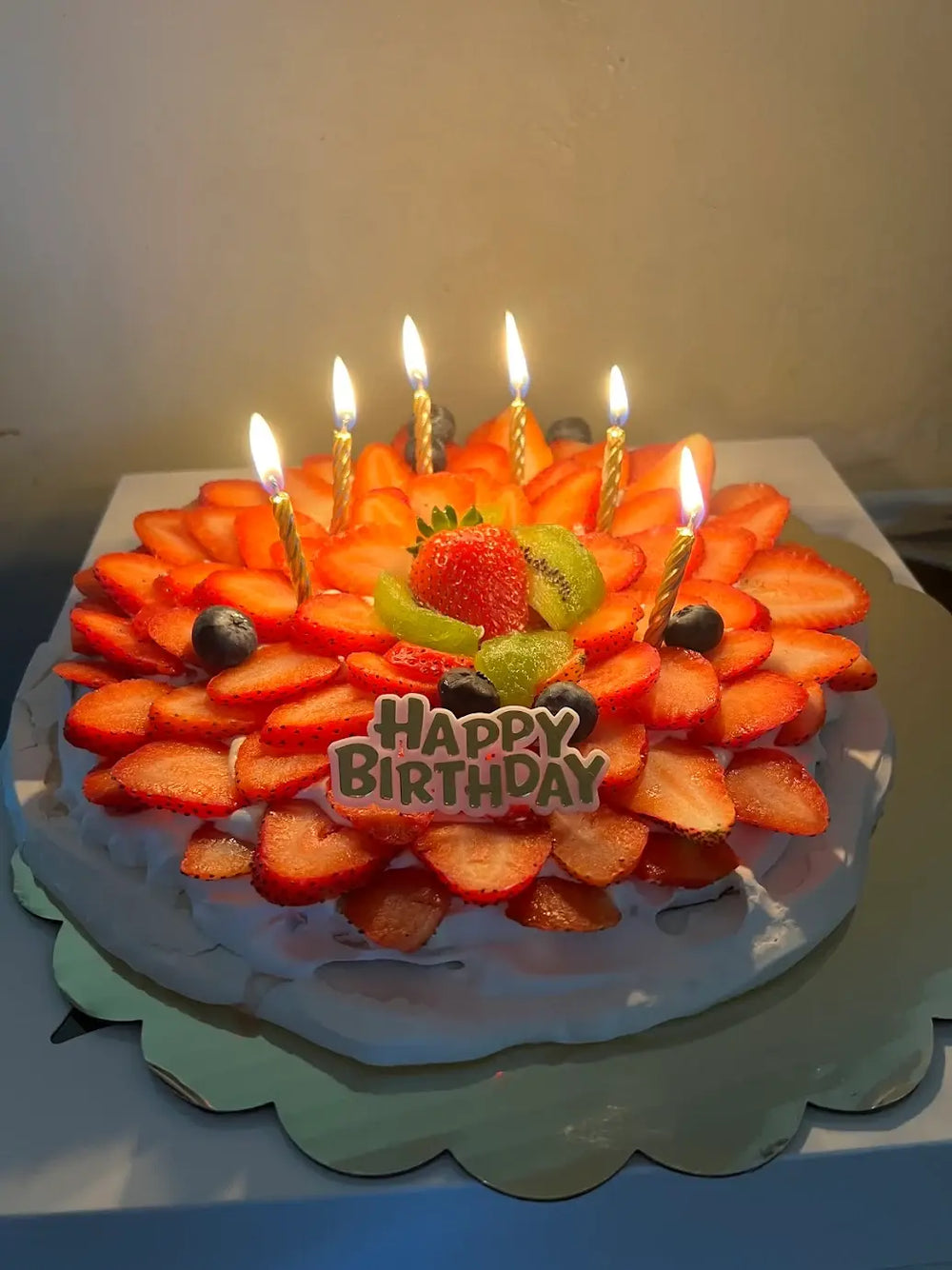 Celebration photo of a strawberry pavlova cake with birthday candles, praised as the best pavlova bakery near me for birthday celebrations in Miami