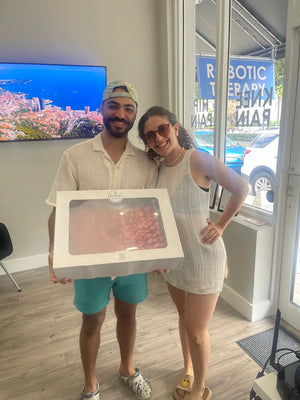 Happy couple picking up a fresh pavlova cake near me at Pavlova Bakery Coral Way, showcasing the best pavlova bakery in Coconut Grove