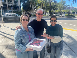 Smiling couple with fresh pavlova cake near me in Midtown Miami, showing local pickup from CakeMiami’s pavlova bakery